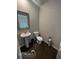 Neutral bathroom with a white sink, toilet, and window, complemented by sleek, dark wood-look flooring at 3604 Sw Wartrace Sw Dr, Atlanta, GA 30331