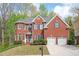 Charming red brick home featuring a two-car garage and manicured front yard at 455 Cooper Woods Se Ct, Smyrna, GA 30082