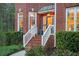 Inviting front porch with brick steps, white railings, and lush green landscaping, at dusk at 455 Cooper Woods Se Ct, Smyrna, GA 30082