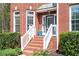 Inviting front porch with brick steps, white railings, and lush green landscaping at 455 Cooper Woods Se Ct, Smyrna, GA 30082