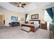 Spacious main bedroom with a sitting area, tray ceilings, a ceiling fan, and a king-size bed at 455 Cooper Woods Se Ct, Smyrna, GA 30082