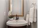 Stylish half bath with a modern vanity, decorative mirror, and fresh white towels at 507 Mirramont Pl, Woodstock, GA 30189
