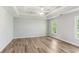 Spacious bedroom featuring a tray ceiling, ceiling fan, and natural light from two windows at 507 Mirramont Pl, Woodstock, GA 30189