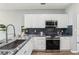 Updated kitchen with stainless steel appliances, granite countertops, and stylish blue backsplash at 507 Mirramont Pl, Woodstock, GA 30189