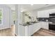Well-lit kitchen with stainless steel appliances, granite countertops, and access to the outdoor deck at 507 Mirramont Pl, Woodstock, GA 30189