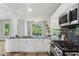 Bright kitchen with stainless appliances, granite countertops, and a view to the outdoor deck at 507 Mirramont Pl, Woodstock, GA 30189