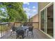 Outdoor deck features a dining table, seating, and wooded views at 507 Mirramont Pl, Woodstock, GA 30189