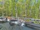 Inviting back porch with table, chairs, and bench overlooks lush green trees at 3500 Lost Valley Dr, Jonesboro, GA 30236
