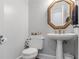Elegant powder room features a pedestal sink, decorative mirror, and classic fixtures at 3500 Lost Valley Dr, Jonesboro, GA 30236