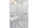Modern bathroom featuring a sleek glass-enclosed shower, pedestal sink, and stylish marble-patterned tile floor at 1216 Beech Valley Ne Rd, Atlanta, GA 30306