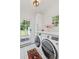Bright laundry room featuring a washer, dryer, and access to the backyard at 1216 Beech Valley Ne Rd, Atlanta, GA 30306