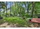 Lush backyard featuring mature trees, a wooden deck, and outdoor furniture for entertaining at 1124 Larosa Sw Ter, Atlanta, GA 30310