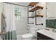 Charming bathroom with modern industrial shelving, and a bathtub with shower at 1124 Larosa Sw Ter, Atlanta, GA 30310