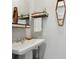 Charming powder room featuring a pedestal sink, unique wall decor, and decorative shelving at 1124 Larosa Sw Ter, Atlanta, GA 30310