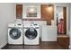 Functional laundry room with brick accent wall, modern washer and dryer, and ample storage space at 1124 Larosa Sw Ter, Atlanta, GA 30310