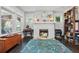 Cozy living room showcasing a decorative fireplace, hardwood floors, and natural light from large windows at 1124 Larosa Sw Ter, Atlanta, GA 30310