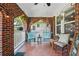 Relaxing front porch with hanging chairs, brick flooring, string lights, and space for outdoor seating at 1124 Larosa Sw Ter, Atlanta, GA 30310