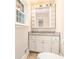 Bright bathroom featuring a granite countertop, white cabinets and a large mirror at 1132 Luther Sw Dr, Mableton, GA 30126