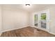 Empty room featuring hardwood floors and french doors leading to a sunroom or porch area at 1132 Luther Sw Dr, Mableton, GA 30126