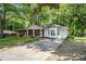 Charming home with brick and white siding, with a long driveway and mature trees at 1132 Luther Sw Dr, Mableton, GA 30126