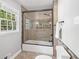 Bathroom featuring a glass shower door, neutral tile, and a window at 3150 Rilman Nw Rd, Atlanta, GA 30327