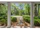Inviting porch with white columns and a brick pathway, surrounded by lush landscaping and mature trees at 3150 Rilman Nw Rd, Atlanta, GA 30327