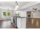 Open kitchen with stainless oven in island overlooking living room with stone fireplace and dark wood floors at 3150 Rilman Nw Rd, Atlanta, GA 30327