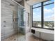 Modern bathroom with glass-enclosed shower, tub, and city views at 3376 Peachtree Ne Rd # 44B, Atlanta, GA 30326