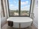 Soaking tub beside large window featuring stunning city views and modern fixtures at 3376 Peachtree Ne Rd # 44B, Atlanta, GA 30326