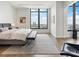 Bedroom with city views, hardwood floors, and a bench seat at the foot of the bed at 3376 Peachtree Ne Rd # 44B, Atlanta, GA 30326