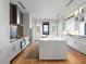 Modern kitchen featuring white cabinetry, stone backsplash, an island, and stainless steel appliances at 3376 Peachtree Ne Rd # 44B, Atlanta, GA 30326