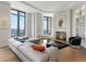 Bright living room with a large sectional sofa, fireplace, and city views from the expansive windows at 3376 Peachtree Ne Rd # 44B, Atlanta, GA 30326