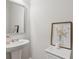 Powder room featuring white pedestal sink with framed mirror above, and a marble-topped accent table at 8609 Lakeview, Jonesboro, GA 30238