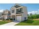 Two-story townhome with a well-maintained lawn, brick accents, and attached garage on a sunny day at 8609 Lakeview, Jonesboro, GA 30238