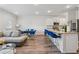 An open-concept living room with a kitchen island, modern seating, and stainless steel appliances at 8609 Lakeview, Jonesboro, GA 30238