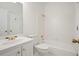 Bright bathroom with white tiling, bathtub, and vanity, complete with gold fixtures at 120 Stanmore Ct, Roswell, GA 30075