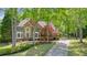 Beautiful brick home featuring a well-manicured lawn, mature trees, and a long driveway at 120 Stanmore Ct, Roswell, GA 30075