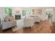 Open living room with a fireplace, large windows, hardwood floors, and modern decor at 120 Stanmore Ct, Roswell, GA 30075