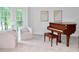 Cozy sitting room with a piano, soft chairs, and natural light from large windows at 120 Stanmore Ct, Roswell, GA 30075