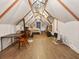 Finished attic space with wood-beamed ceiling, laminate flooring, and a ceiling fan plus sleeping area at 1480 Niskey Lake Sw Rd, Atlanta, GA 30331