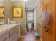 Bathroom features a toilet, single sink vanity, framed artwork, and tile flooring, plus a window view at 1480 Niskey Lake Sw Rd, Atlanta, GA 30331