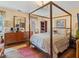 Main bedroom features a four-poster bed, wooden floors, and a large dresser, plus an area rug at 1480 Niskey Lake Sw Rd, Atlanta, GA 30331