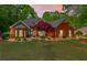 Charming brick home featuring manicured landscaping and a well-maintained lawn at dusk at 235 Huiet Dr, Mcdonough, GA 30252