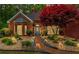 Beautifully landscaped front yard with manicured shrubbery and walkway to front door at dusk at 235 Huiet Dr, Mcdonough, GA 30252