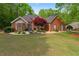 Charming brick home with a lush green lawn and manicured landscaping enhances its welcoming exterior at 235 Huiet Dr, Mcdonough, GA 30252
