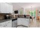 Well-lit kitchen with white cabinetry, granite countertops, stainless steel appliances, and a view to the breakfast nook at 235 Huiet Dr, Mcdonough, GA 30252