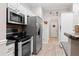 Galley-style kitchen featuring stainless steel appliances and wood floors at 235 Huiet Dr, Mcdonough, GA 30252