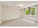 Basement featuring carpet floors, paneled walls, drop ceiling and a single window to the outdoors at 239 Devonwood Dr, Atlanta, GA 30328