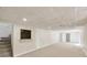 Basement with neutral carpet, white paneled walls, drop ceiling tiles and access to another room at 239 Devonwood Dr, Atlanta, GA 30328