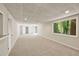 Finished basement area with neutral carpet, white walls, a drop ceiling, and a view to the exterior at 239 Devonwood Dr, Atlanta, GA 30328